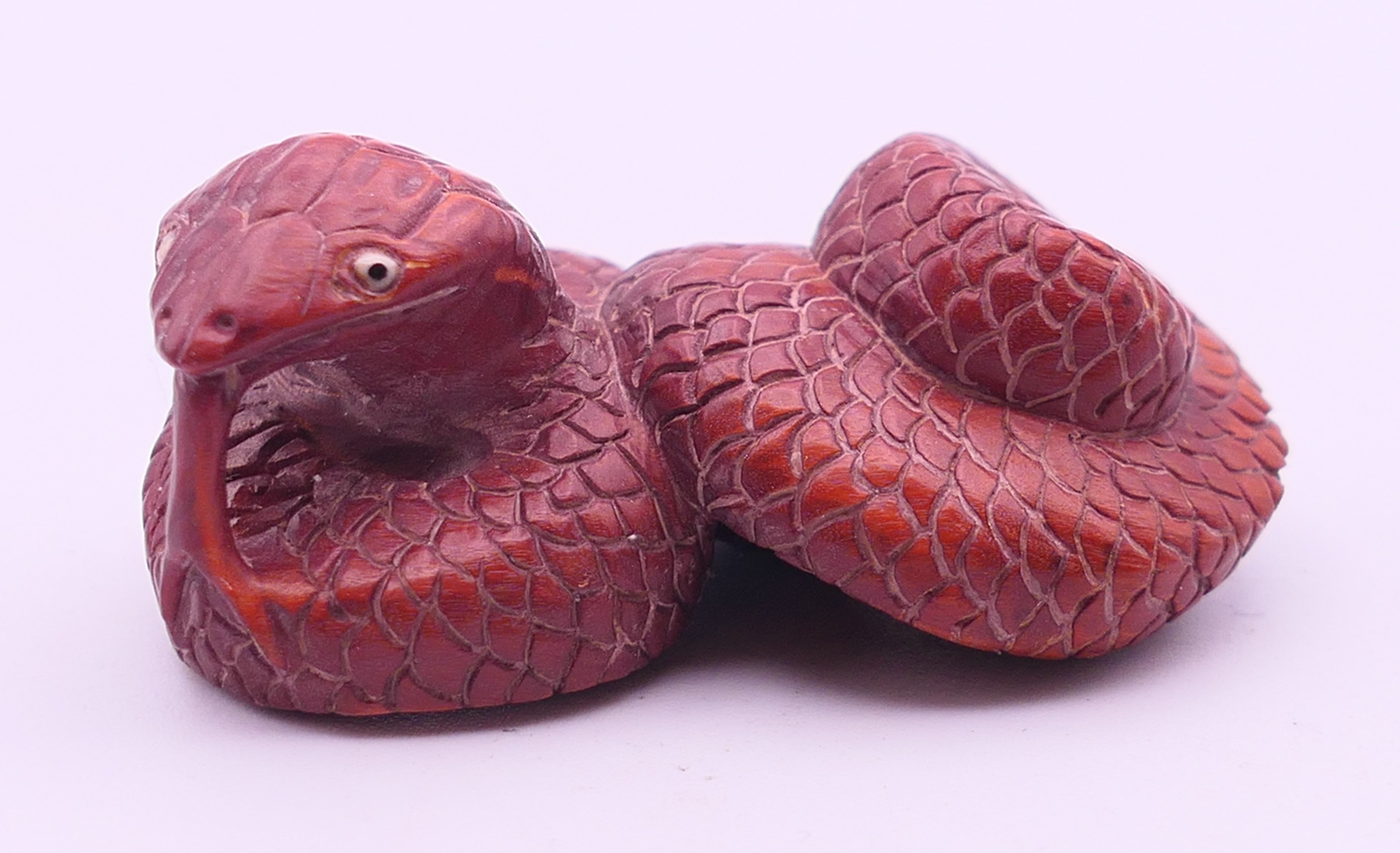 A wood snake-form netsuke. 5.5 cm long.