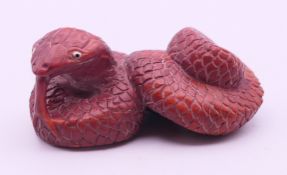 A wood snake-form netsuke. 5.5 cm long.