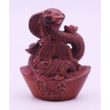 A Chinese wood snake and yuanbao wealth ingots model. 6 cm high.