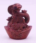 A Chinese wood snake and yuanbao wealth ingots model. 6 cm high.