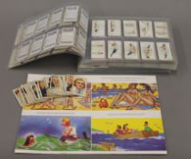 A collection of vintage cigarette cards and a 1993 Saucy Seaside postcard book.