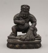 A carved stone model of the Buddhist deity Jambhala (Dzambhala). 15 cm high.