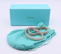 A boxed Tiffany & Co silver necklace. 1.2 cm high, 43 cm long. 81 grammes.
