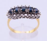 An 18 ct gold, diamond and sapphire ring. Ring size Q/R. 4.9 grammes total weight.