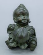 A Japanese bronze of a boy with a peach. 8 cm high.