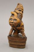 A treen three-faced carving, mounted on a stepped base. 15 cm high.