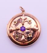 A 9 ct gold and amethyst locket. 3 cm diameter. 8.8 grammes total weight.