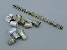 A quantity of various silver and other thimbles and a silver comb back. The latter 18.5 cm long. 26.