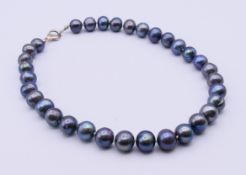 A single strand freshwater black pearl necklace. 42 cm long.