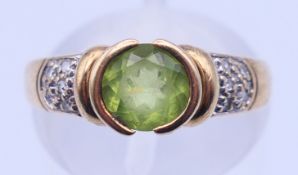 A 9 ct gold, peridot and diamond ring. 2.5 grammes total weight. Ring size L.