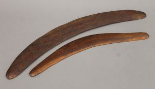 An Aboriginal carved wooden boomerang and another smaller boomerang. The former 63 cm long.