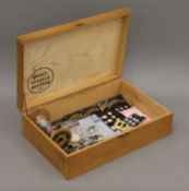 A wooden box containing vintage buttons, trimmings etc. The box 36 cm wide.