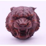 A wooden carving formed as the head of a wolf. 3 cm high.