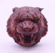 A wooden carving formed as the head of a wolf. 3 cm high.