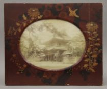 A late 19th/early 20th century Japanese lacquered frame housing a picture of a pagoda. 37 cm wide.
