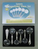 A boxed set of magnifying glasses. The box 21.5 cm wide.