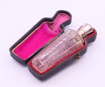 A boxed silver-topped glass scent bottle. 9 cm high.