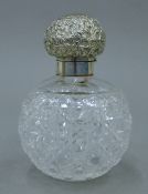 A silver-topped cut glass scent bottle. 13 cm high.