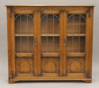 A lead-glazed carved oak display cabinet. 139 cm wide x 126.5 cm high.
