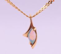 A 14 K gold and opal pendant on an 18 ct gold chain. Pendant 2 cm high, chain 50 cm long. 7.