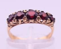 A 9 ct gold five stone garnet ring. Ring size K/L. 2.2 grammes total weight.