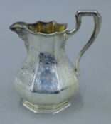 A Victorian engraved silver cream jug. 13.5 cm high. 230.1 grammes.