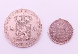An 1874 Netherlands 2 1/2 Gulden coin and an 1881 India-Portuguese Meia Rupia coin.