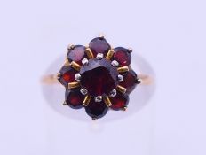 A 9 ct gold and garnet cluster ring. Ring size L/M. 2.8 grammes total weight.