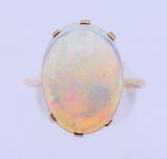 An unmarked 9 ct gold and opal ring. Opal 1.7 x 1.2 cm, ring size U/V. 2.8 grammes total weight.