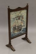 An early 20th century oak-framed tapestry fire screen depicting a galleon. 49 cm wide.