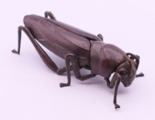 An articulated bronze locust. 9 cm long.