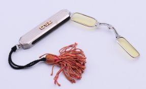 A slim folding lorgnettes in red leather case. 7 cm long including suspension loop.
