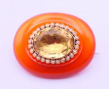 A 19th century unmarked gold mounted citrine and seed pearl brooch. 2.5 x 2 cm.