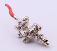 A silver child's rattle. 14 cm high.