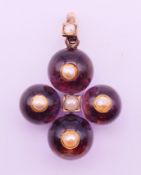 An unmarked gold, amethyst and pearl cross pendant. 4 cm high including suspension loop.