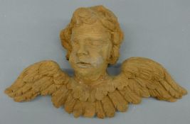 A 19th century carved pine cherub surmount. 31 cm wide.