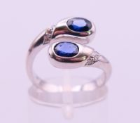 An 18 ct white gold, sapphire and diamond snake head ring. Ring size M/N. 5.7 grammes total weight.
