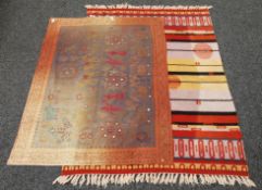 An orange ground rug and an Eastern mirror-inset wall hanging. The latter 98 x 140 cm.