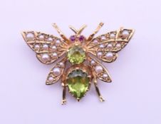 A 9 ct gold, peridot and seed pearl bee brooch. 2 cm high x 2.75 cm wide. 3.8 grammes total weight.