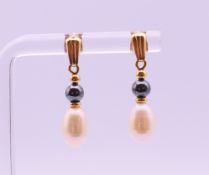 A pair of 18 ct gold and pearl drop earrings with 18 ct gold butterfly clips. 2.5 cm high.