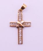 A 9 ct gold cross form pendant. 2.5 cm high. 1.3 grammes total weight.