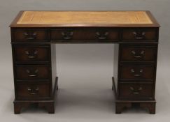 A leather-topped pedestal desk. 121 cm wide x 61 cm deep.
