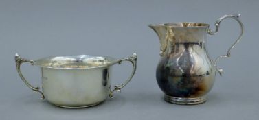 A silver cream jug and a twin-handled silver sugar bowl. The latter 14 cm wide. 285.5 grammes.