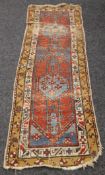 A red ground wool runner. 76 x 249 cm.