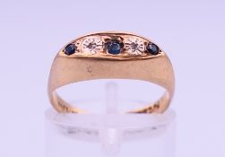 A 9 ct gold five-stone diamond and sapphire ring. Ring size J/K. 2 grammes total weight.