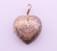 A white metal heart shaped vinaigrette pendant. 3.5 cm high excluding suspension loop.