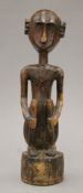 A vintage Solomon Islands carving of a man sitting on his haunches,