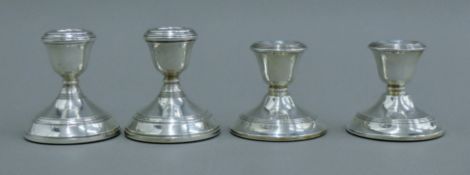 Two pairs of silver dwarf candlesticks. The larger pair 8 cm high.
