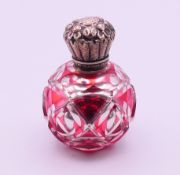 A Victorian unmarked silver topped overlay mirror glass scent bottle and stopper. 7 cm high.