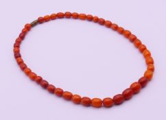 A small amber bead necklace. 41 cm long, central bead 0.8 x 1 cm.
